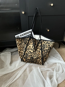 Detail of leopard print canvas tote bag with black strap and large capacity texture