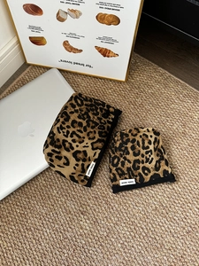 Dettaglio di due borse per cosmetici con stampa leopardata e cerniera su tappeto