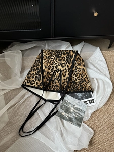Detail view of leopard print canvas tote bag with black straps and thick material