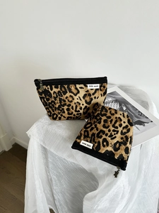 Dettaglio del set di borse per trucco leopardate in tela con cerniera e etichetta