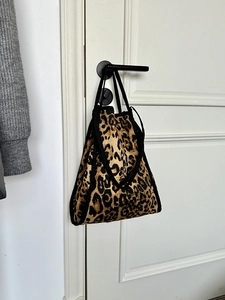 Detail view of large leopard print canvas tote bag hanging on a door handle