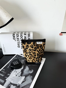 Dettaglio ravvicinato della borsa trucco in tela leopardata con cerniera e logo