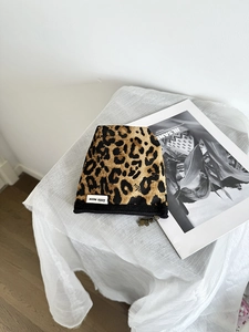 Dettaglio borsa per cosmetici leopardata in tela con cerniera e logo distintivo