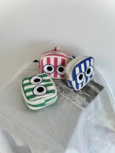 Detailed view of canvas mini pouches with striped patterns and embroidered eye design