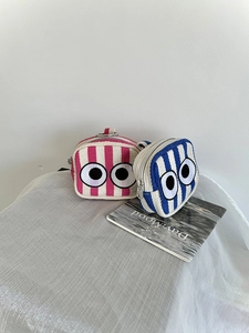Detail of canvas mini coin purses featuring striped patterns and embroidered eyes