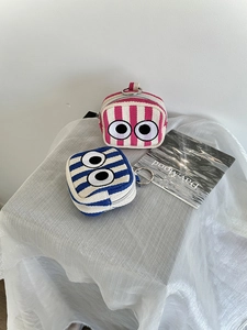 Close-up of striped canvas mini pouches with big eye embroidery and metal ring