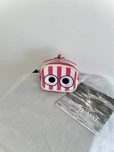 Detailed embroidery of cartoon eyes on a pink striped canvas mini storage bag with ring