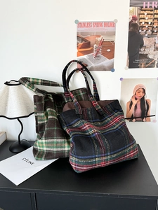 Macro detail of high-capacity plaid wool tote bags in classic checkered patterns