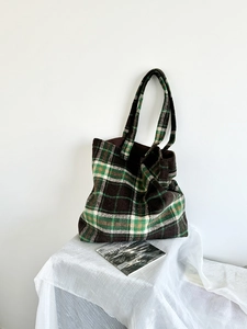 Detail of checkered wool tote bag with thick texture and deep brown flannel finish