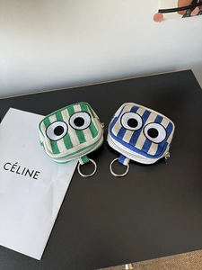 Detailed view of striped canvas mini bags with embroidered eyes and silver key rings