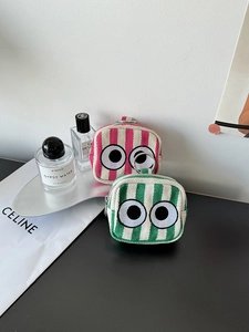 Detailed view of mini striped canvas coin pouches with big eyes embroidery and silver zip