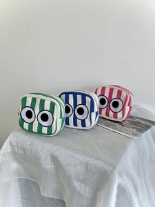 Detailed view of mini striped pouches with cute eye embroidery and silver zippers