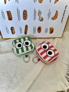 Detailed view of mini striped pouches with eye embroidery and metal key rings