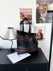 Detail of colorful plaid wool tote bag with soft indoor lighting and vintage aesthetic