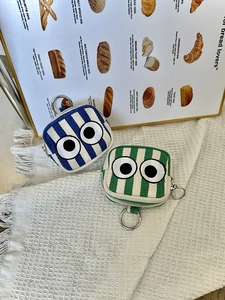 Detail of canvas mini pouches with stripe patterns, big eye embroidery and metal hooks