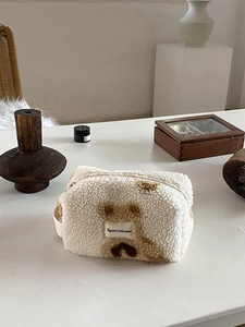 Detail of plush lamb wool makeup bag with brown spots and star moon label