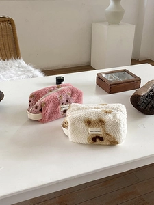 Detail of plush lamb wool makeup bags with cute bear pattern and zipper closure
