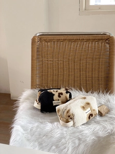 Detail of leopard print plush cosmetic bags with metal zipper and side woven handle