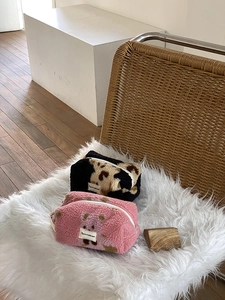 Close-up of plush cosmetic bags featuring cute bear pattern and stylish cow print texture