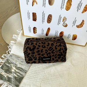 Detailed texture of leopard print corduroy makeup bag with secure metal zipper closure