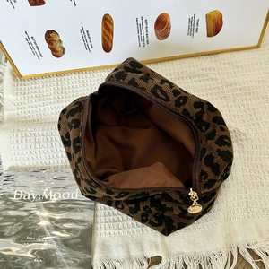 Detail of leopard print corduroy cosmetic bag with gold zipper and smooth lining