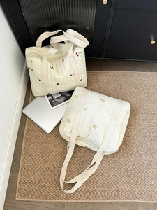 Detailed view of quilted cotton tote bags featuring cherry and lemon embroidery patterns