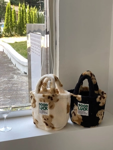 Close-up of mini fuzzy teddy bucket bags with brown bear prints and Good Luck patch