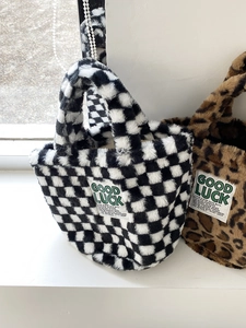 Detailed view of plush teddy fabric tote bags in checkerboard and leopard patterns