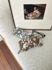 Detailed embroidery floral pattern and cat-shaped metal zipper puller on storage pouch