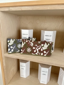 Detailed close-up of blue and red embroidered flower pouches on a wooden shelf