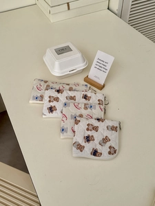 Detailed view of quilted cotton teddy bear storage bags with silver metal zippers