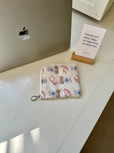 Quilted cotton pouch with puppy print and zipper detail on a minimalist desk