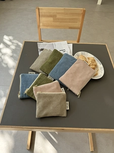 Nahaufnahme der Cord-Kosmetiktaschen in sanften Morandi-Farben mit Etikett und Reißverschluss