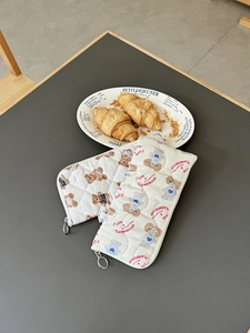 Close-up of quilted storage pouches with cute cartoon bear and poodle prints