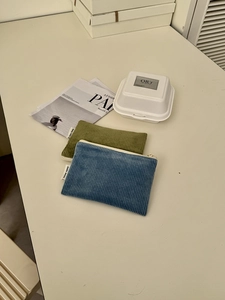 Detailansicht der olivgrünen und graublauen Cord-Taschen mit Metallreißverschlüssen