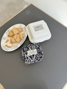 Detail of embroidered navy mini organizer bag on a cafe table with French decor