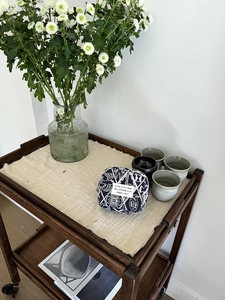 Detailed view of embroidery canvas organizer bag on a rustic table with daisy flowers