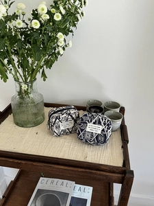 Detail view of two vintage embroidered canvas mini pouches on a retro wooden shelf