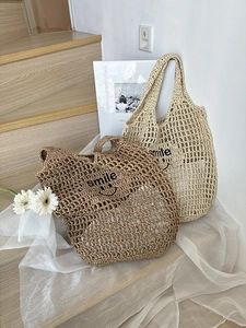 Detailed texture of hollow woven straw bags with smile embroidery on wood stairs