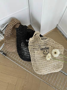 Detail of hand-crocheted woven tote bags with smile embroidery in khaki and beige