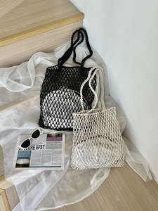 Nahaufnahme von geflochtenen Netztaschen in Schwarz und Creme mit hohler Strickstruktur