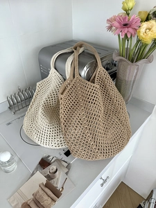 Detail of hollow woven cotton rope tote bags in cream and khaki for summer beach vacations