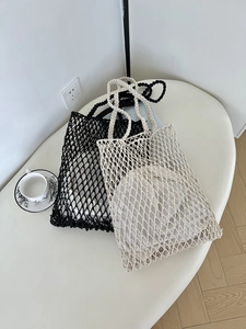 Detail der Strickstruktur handgefertigter Netztaschen in den Farben Schwarz und Beige