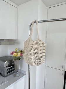 Close-up of cream handmade crochet tote bag with hollow diamond mesh pattern