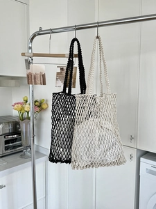 Detail der handgewebten Hohlnetz-Tragetaschen in Schwarz und Beige mit verstärktem Griff