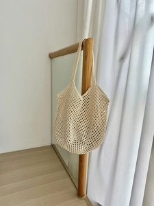Detail of beige hollow-out cotton rope crochet bag with intricate woven diamond mesh
