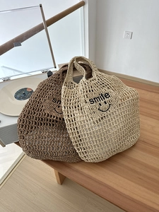 Detail of hollow knit tote bags with smile embroidery in beige and brown colors