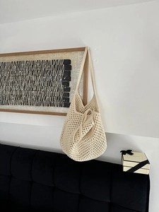 Detailed macro view of cream hollow knit cotton rope shoulder bag with woven texture