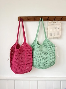 Detailed view of hollow knit cotton rope shoulder bags with drawstring in pink and green