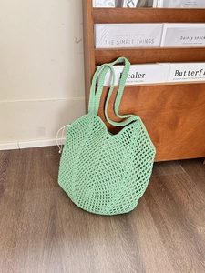 Detail of mint green crochet cotton bag with hollow mesh and secure drawstring closure